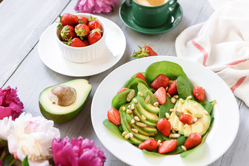 breakfast vegan salad with avocado, strawberries, pine nuts