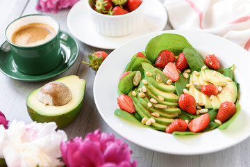breakfast vegan salad with avocado, strawberries, pine nuts