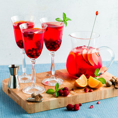 fresh summer red sangria from ripe fruits and berries, as well as wine on the table in glasses and a decanter. spices and mint leaves