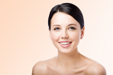 Smiling young woman on light background. Perfect clean skin