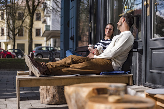 Man and woman sitting outside a cafe talking