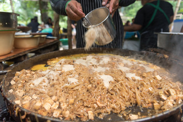 Close up movement hand the chef cooking Pad Thai in a pan.