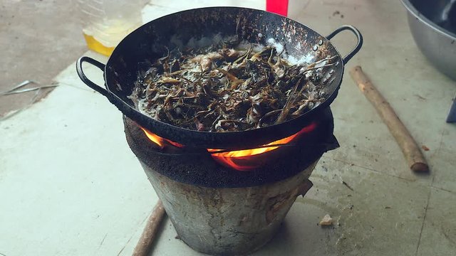 Deep-frying frogs in a wok over a household stove ( close up )