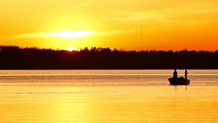 Silhouette of father and son fishing on Lake Irving at sunset in Bemidji, Minnesota. - Powered by Adobe