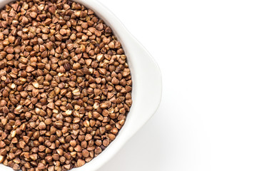 buckwheat groats in a white bowl on a white background close up flat lay