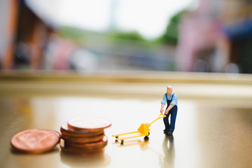 Miniature people, man moving stack coins, using for logistic, business and finance concept