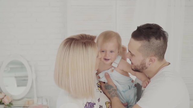 Happy parents kissing their beautiful lovely daughter. Happy family. Slow motion