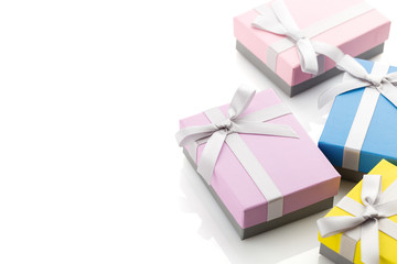 Small colorful gift boxes with ribbon bows on white background