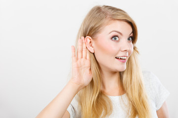 Woman putting hand ear to hear better
