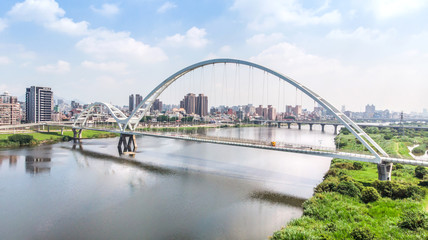 Naklejka premium Crescent Bridge - landmark of New Taipei, Taiwan with beautiful illumination at day, aerial photography in New Taipei, Taiwan.