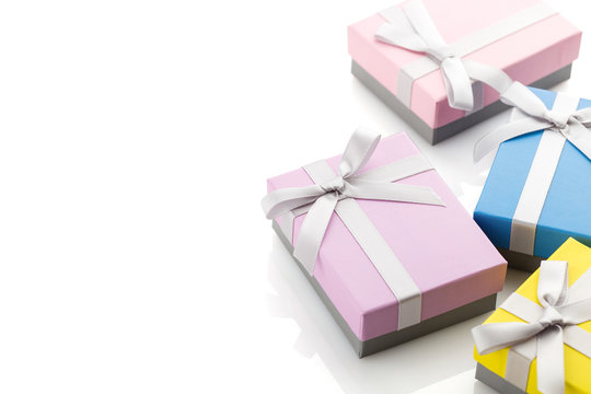 Small colorful gift boxes with ribbon bows on white background