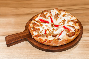 Fast food italian traditional.Hot chicken sausage pizza with cheese, imitation crab stick on wooden board table classic in top view.Closed up.Copy space.