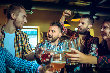 Sport, people, leisure, friendship and entertainment concept - happy football fans or male friends...