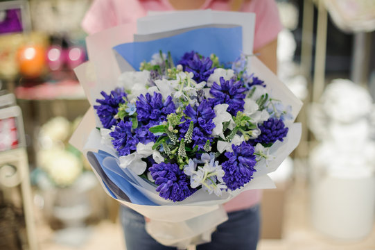 Girl holding a beautiful bouquet of white and blue tender flowers