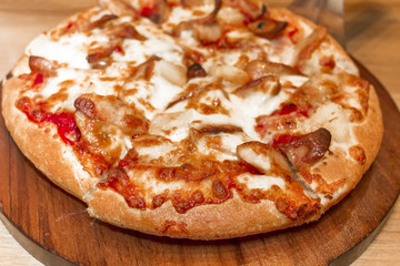 Fast food italian traditional.Hot chicken sausage pizza with cheese, imitation crab stick on wooden board table classic in top view.Closed up.Copy space.