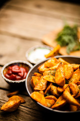 Baked potato fries on wooden table