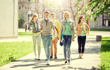 education, high school, communication and people concept - group of happy teenage students walking outdoors