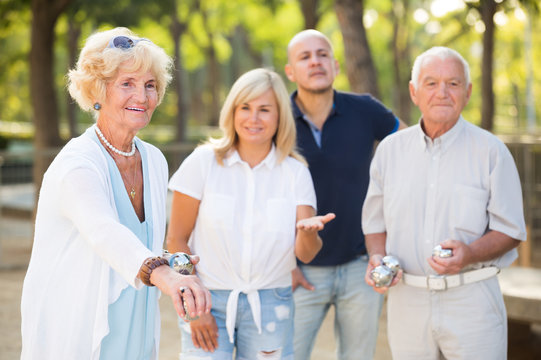 Group of positive mature people playing petanque