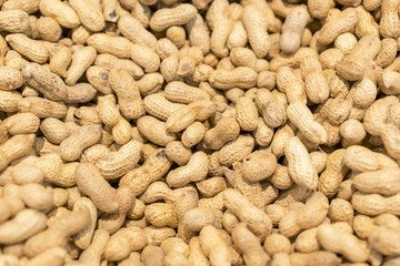 Peanuts in shell texture background. Raw peanuts on display at a farmer's market. unpeeled peanut...