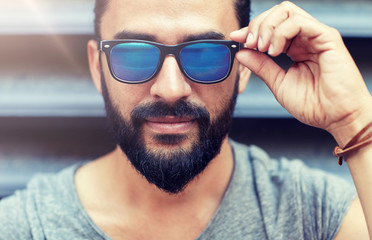 lifestyle, emotion, expression and people concept - happy smiling man with sunglasses and beard on...