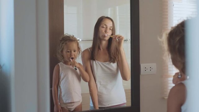 Family brushing teeth with a tooth brush in bathroom