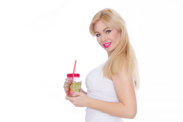 A friendly blond woman holds a glass of water and lime in her hands. A girl is drinking lemonade. Concept - healthy food, thirst quenching in summer
