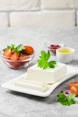 Goat cheese on plate with tomatoes, herbs, olive oil and spices. Selective focus, space for text. 