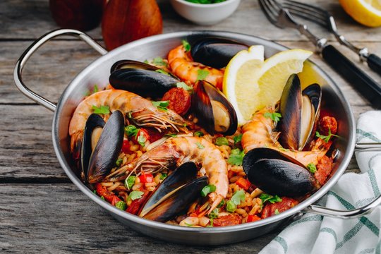 Spanish seafood paella with mussels, shrimps and chorizo sausages in traditional pan
