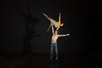 Jóvenes realizando ejercicios de portes acrobáticos en estudio de fotografía