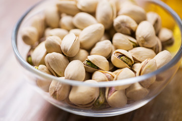 food concept - close up of pistachio nuts in glass bowl