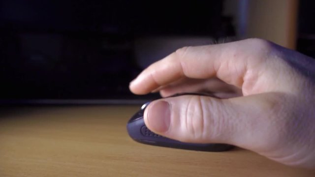 The hand falls on the computer mouse. Slow-motion shooting of 480 frames per second