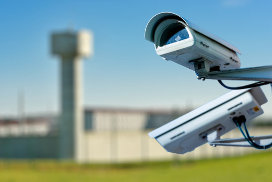 security CCTV camera or surveillance system with prison on blurry background