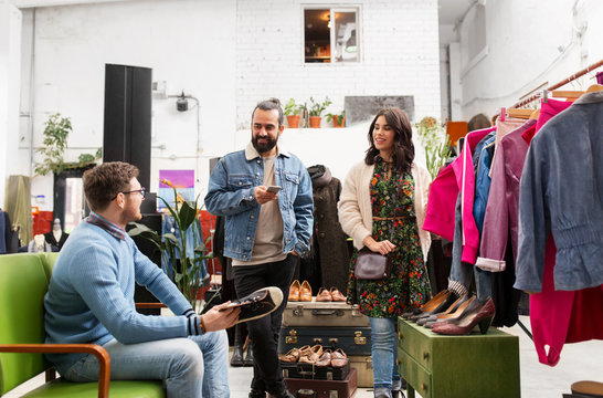 sale, shopping, fashion and people concept - friends choosing clothes and footwear at vintage clothing store