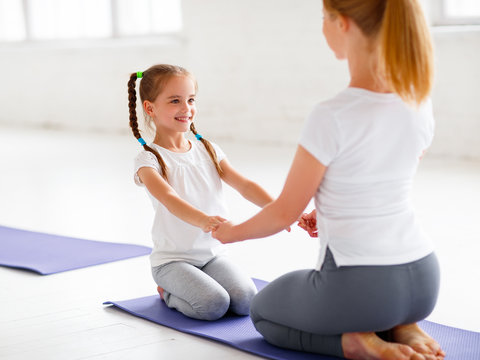 mother with child practicing yoga in lotus pose