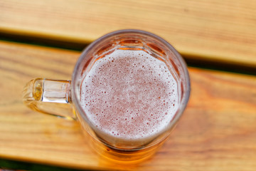 Pint of beer on the wooden table in te garden