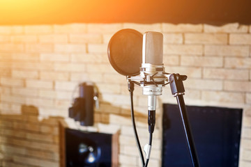 Music studio. Silver condenser microphone with pop filter - Powered by Adobe