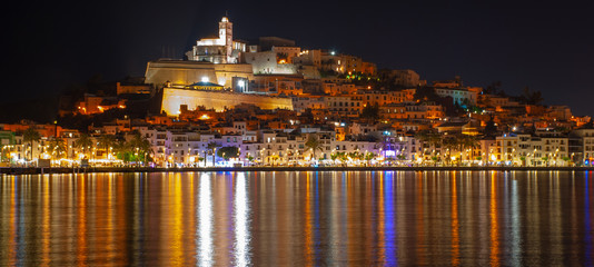 Fototapeta na wymiar Ibiza town and castle seen at night reflected across the water,