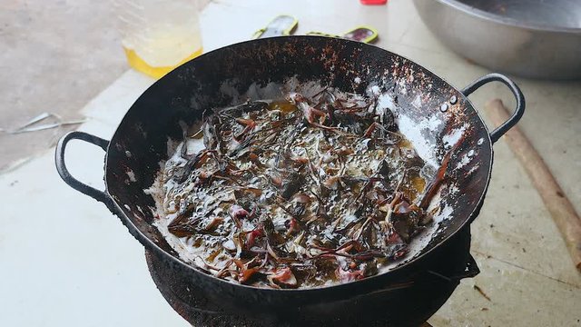 Deep-frying frogs in a wok over a household stove ( close up )