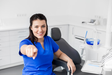 dentistry, medicine and healthcare concept - smiling female dentist or nurse at dental clinic...