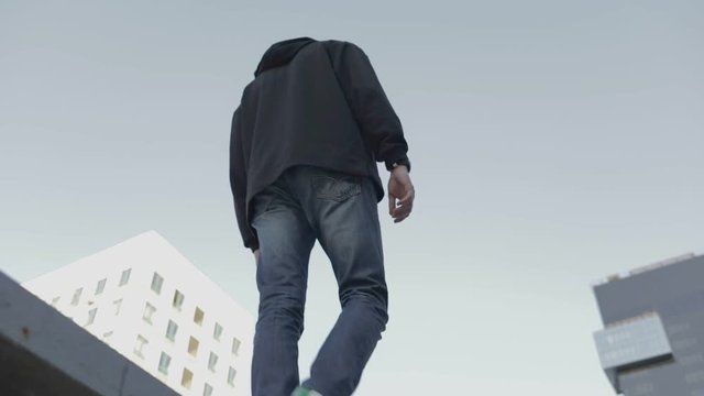 Bottom view of a guy in a black sweatshirt. City urban style. Slow motion video shooting by handheld gimbal