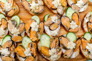 Canape with mussels cucumbers and butter .