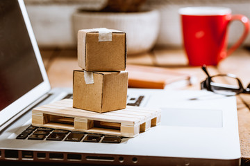 Carton boxes on computer as online shopping logistics concept