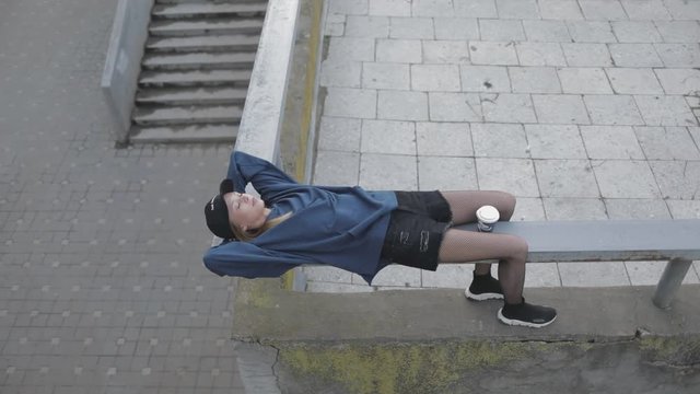 Beautiful young gitl woman relaxing at street. City urban style. Slow motion video shooting by handheld gimbal