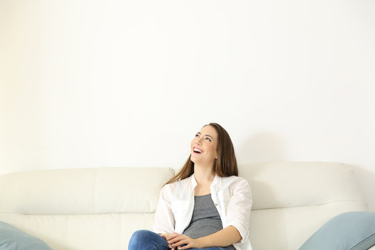 Woman sitting on couch and looking above