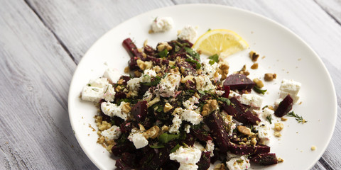 Beetroot salad with cottage cheese and walnuts. European cuisine. Organic food. Vegetarian appetizer. Simple side dish. Wide photo.