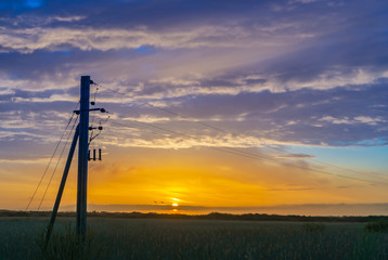 Fototapeta na wymiar Sunrise with power masts in the foreground