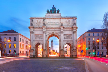 The Siegestor or Victory Gate, triumphal arch crowned with a statue of Bavaria with a lion-quadriga, during evening blue hour in Munich, Germany