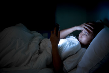 Asian woman play smartphone in the bed at night,Thailand people