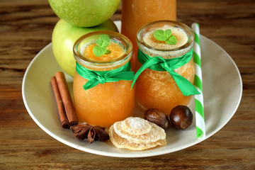 Apple beverage with candied ginger and different spices in glass jars