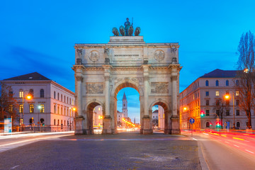 Fototapeta na wymiar The Siegestor or Victory Gate, triumphal arch crowned with a statue of Bavaria with a lion-quadriga, during evening blue hour in Munich, Germany
